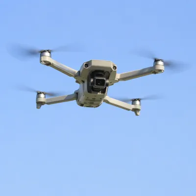 Professional Drone Hovering in Clear Blue Sky