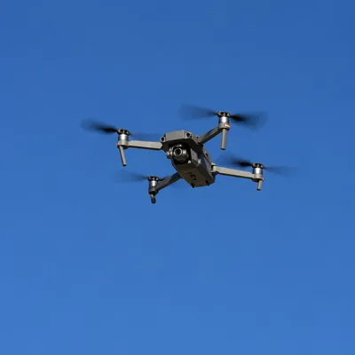 Quadcopter Drone Hovering in Clear Blue Sky