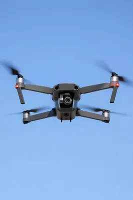Modern Camera Drone Hovering in Blue Sky