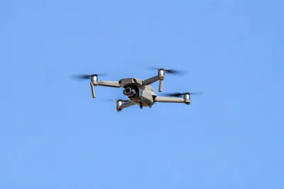 Quadcopter Drone Hovering in Clear Blue Sky