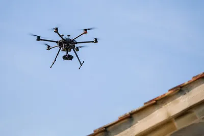 Professional Drone Hovering in Clear Blue Sky
