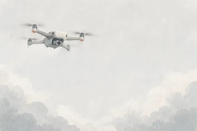 White Drone Hovering in Overcast Sky