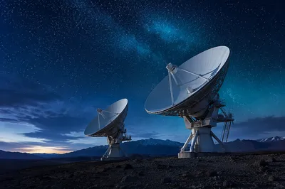 Satellite Dishes Under Starry Blue Sky