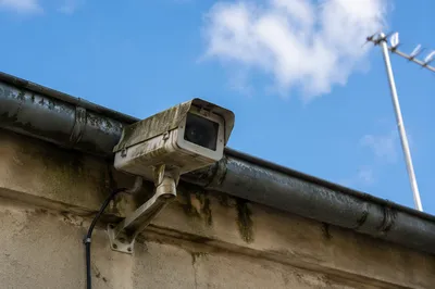 Weathered Exterior Security Camera Under Roofline