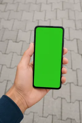 Hand Holding Smartphone With Green Mockup Screen
