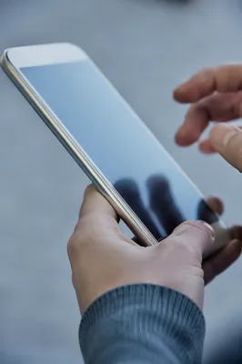 Hand Holding Smartphone with Blank Blue Screen