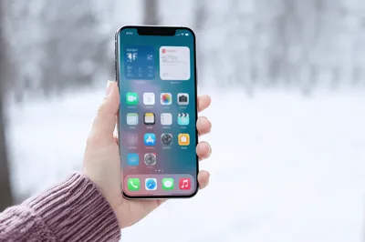 Hand Holding Smartphone in Snowy Winter Light