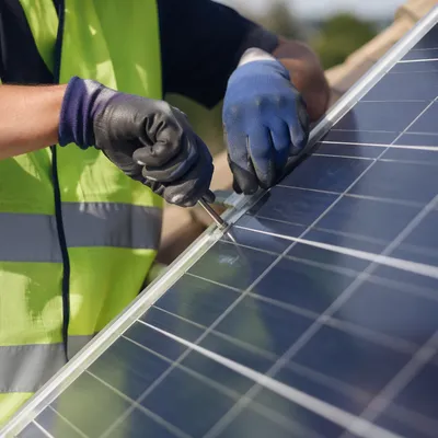 Technician Installing Solar Panel on Rooftop
