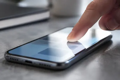 Fingertip Tapping Smartphone in Modern Workspace