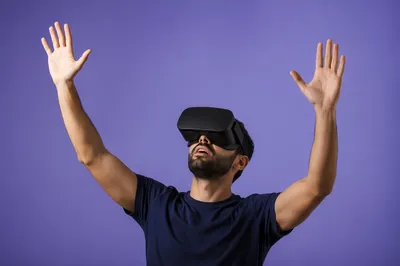 Person in VR Headset With Raised Hands