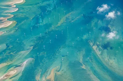 Offshore Wind Turbines Over Turquoise Coastal Waters