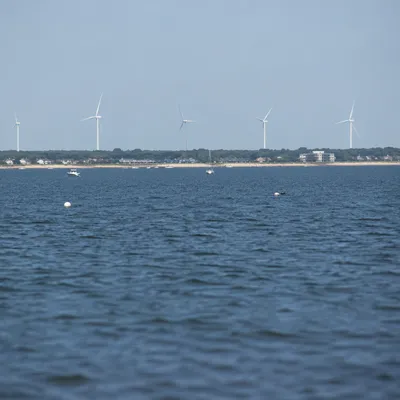 Coastal Wind Turbines Over Calm Blue Water