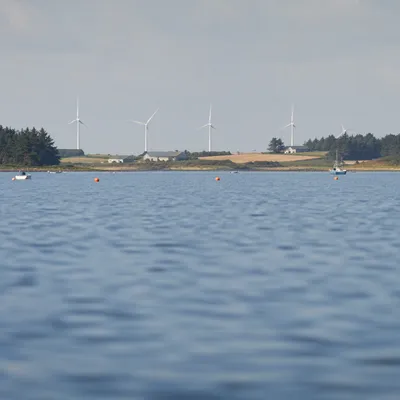 Coastal Wind Turbines Over Calm Blue Water