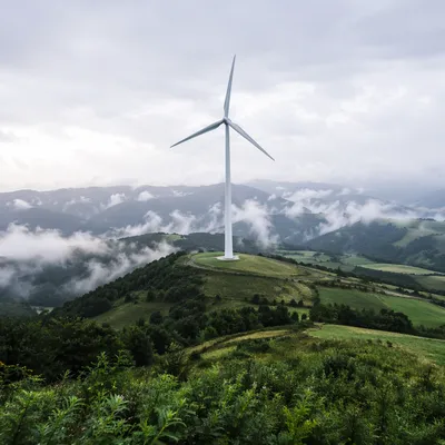 Wind Turbine Over Misty Green Hills