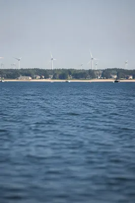 Coastal Wind Turbines Over Calm Blue Water