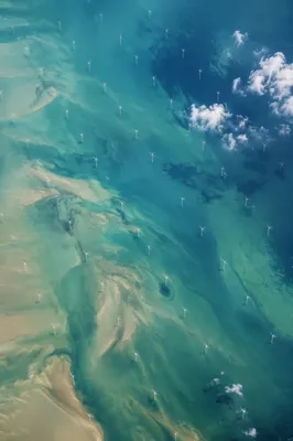 Offshore Wind Turbines Over Turquoise Coastal Waters