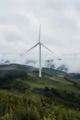 Wind Turbine Over Misty Green Hills