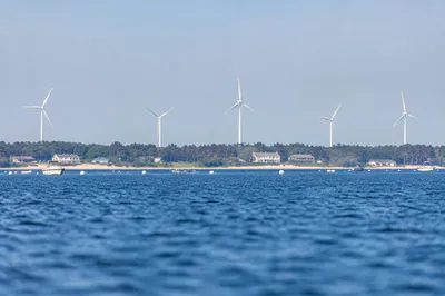 Coastal Wind Turbines Over Calm Blue Water