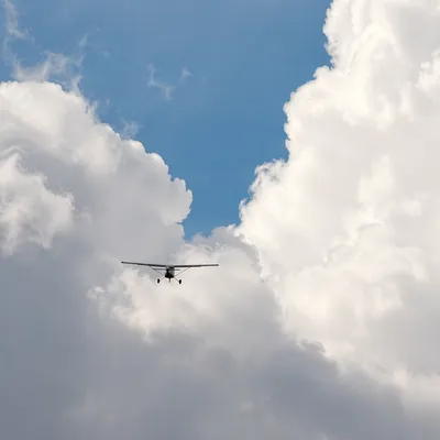 Airplane Soaring Through Towering Clouds