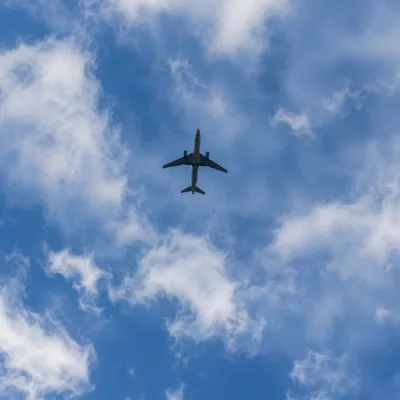 Airplane Silhouette Above Blue Clouded Sky