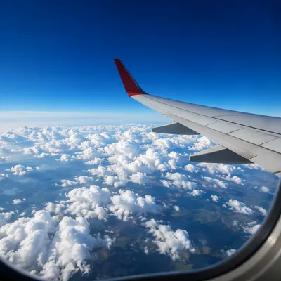 Airplane Window View Above Bright Clouds