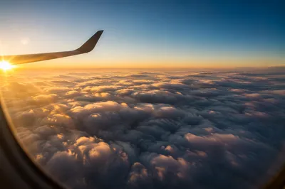 Airplane Window View Above Golden Clouds