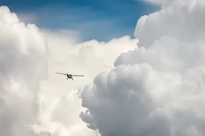 Airplane Flying Through Towering Clouds