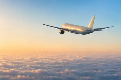 Passenger Airplane Above Morning Clouds