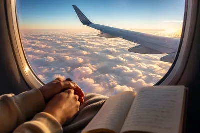Peaceful Airplane Window Above Sunlit Clouds
