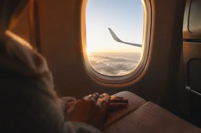 Peaceful Airplane Window Sunrise Above Clouds