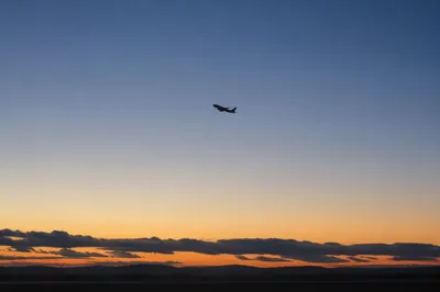 Airplane Taking Off into Blue Dawn Sky