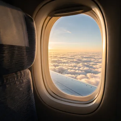 Sunlit Clouds Through Airplane Window