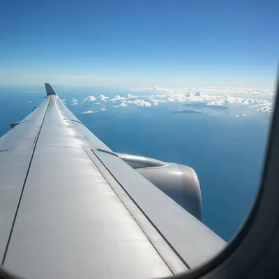 Airplane Window View Above Ocean Clouds