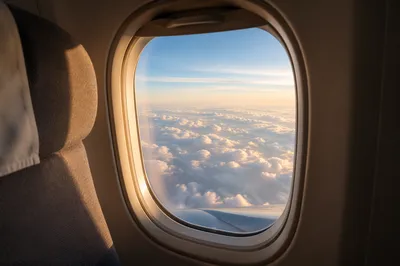Sunlit Clouds Through Airplane Window