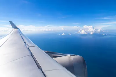 Airplane Window View Above Ocean Clouds