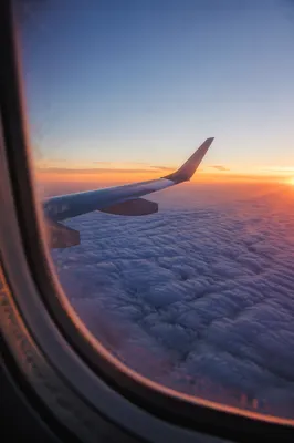 Airplane Wing Above Clouds at Sunrise