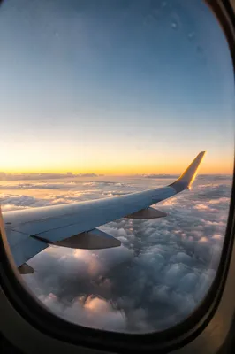 Airplane Wing Above Clouds at Sunrise