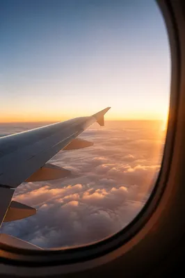 Airplane Wing Above Clouds at Sunrise