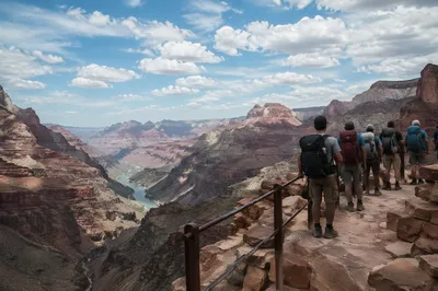 Backpack Hikers Overlooking Desert Mountain Canyon