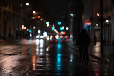Nighttime Cyclist on Rainy City Street