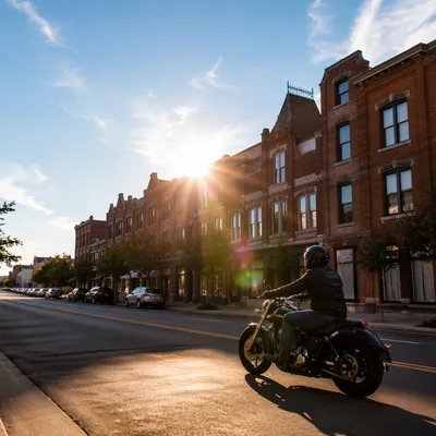 Lone Motorcycle Rider on Sunlit Main Street
