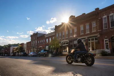 Lone Motorcycle Ride Through Sunlit Main Street