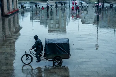 Rainy City Street Reflections with Umbrella Commute