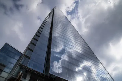 Modern Glass Skyscraper Under Cloudy Sky