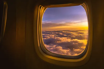 Golden Sunset Clouds Through Airplane Window