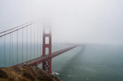 Misty Rust Red Suspension Bridge Over Bay