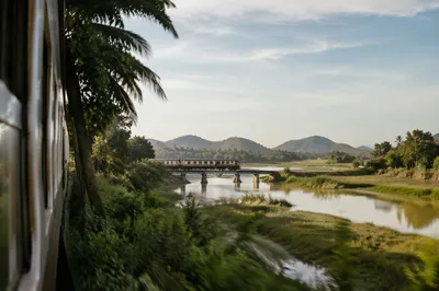 Passenger Train Crossing Rural River Bridge