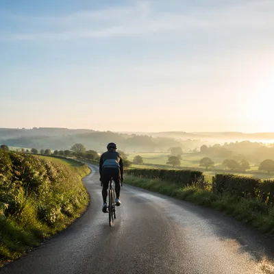 Lone Cyclist on Misty Country Road