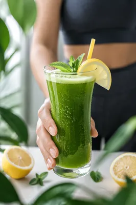 Hand Offering Fresh Green Wellness Juice