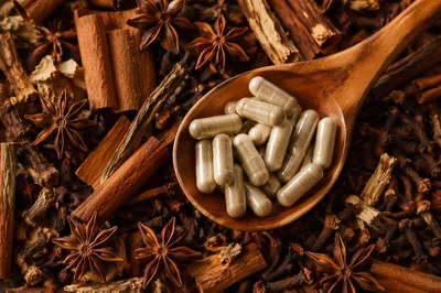 Natural Herbal Capsules in Wooden Spoon